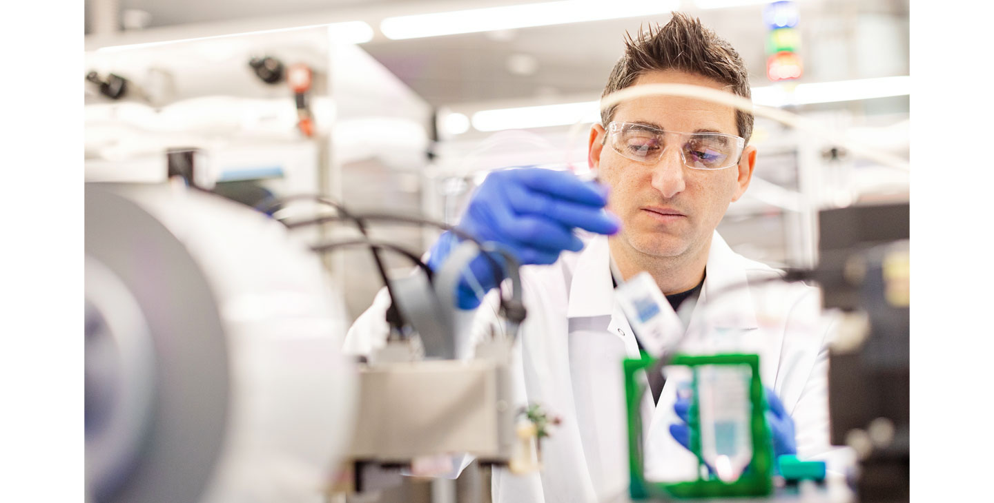 Учен в изследователска лаборатория на Амджен